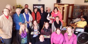 â€˜n Groep gaste en personeel van Grootbos Foundation het â€œselfgebakteâ€ koekies vir HaS se inwoners en personeel gebring en ook lekker met hulle gesels, met Michael Lutzeyer (Besturende Direkteur: Grootbos Natuurresservaat) gesellig plat op die vloer tussen die dames.